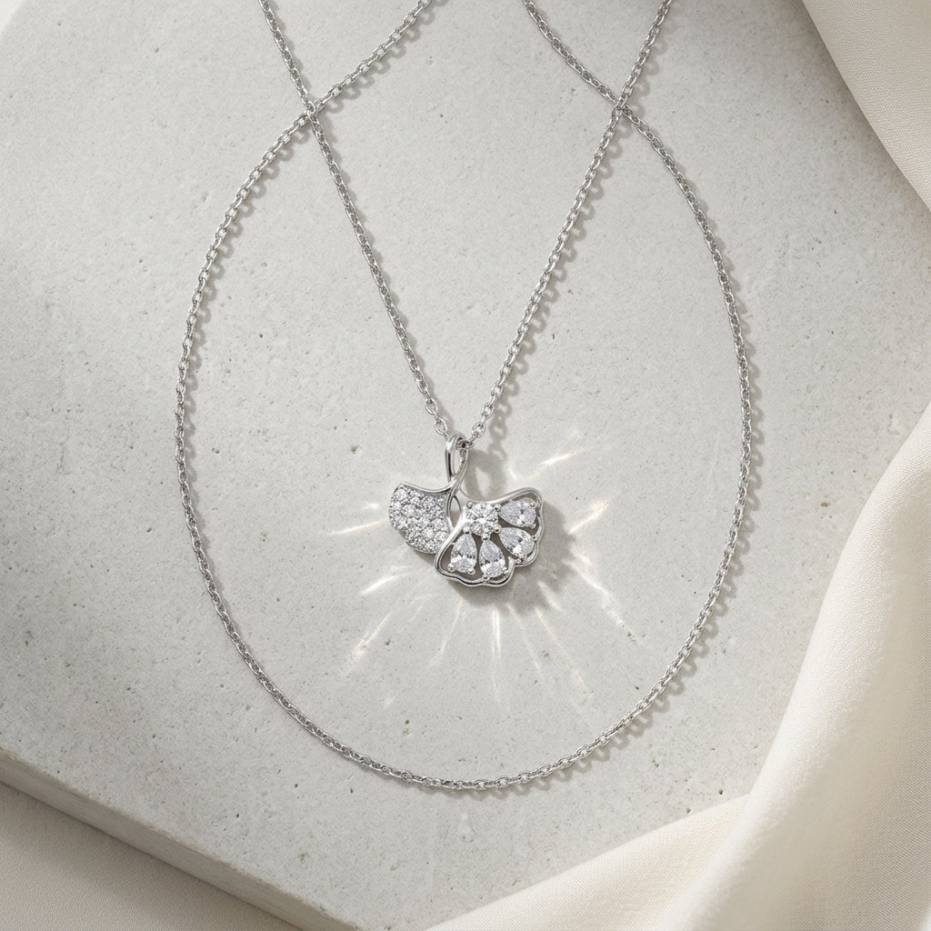 nature inspired ginkgo leaf silver pendant necklace on white stone background
925 sterling silver ginkgo leaf pendant necklace with cubic zirconia stones