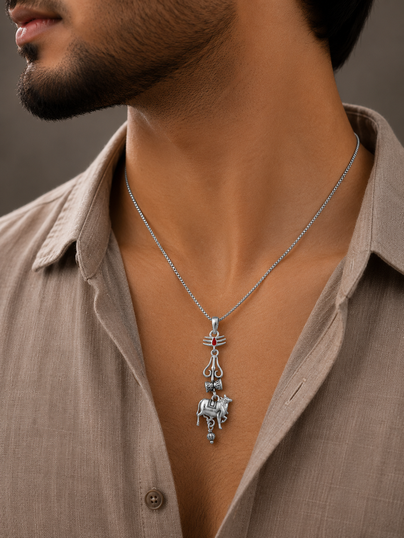 Man wearing a silver SSMB varanasi pendant with a detailed pendant against a neutral background