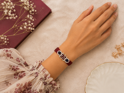 Multi-strand crimson bracelet with premium CZ centerpiece