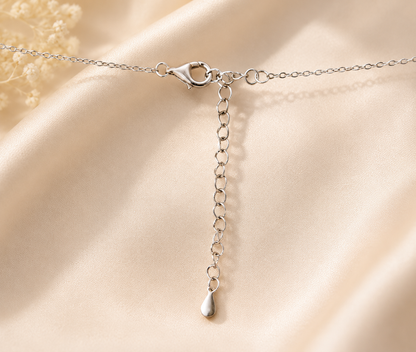 Delicate silver chain attached to square halo pendant with sparkling CZ center stone