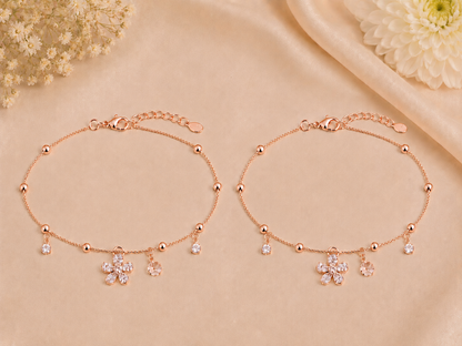 Rose gold bracelet with floral charms on a beige background